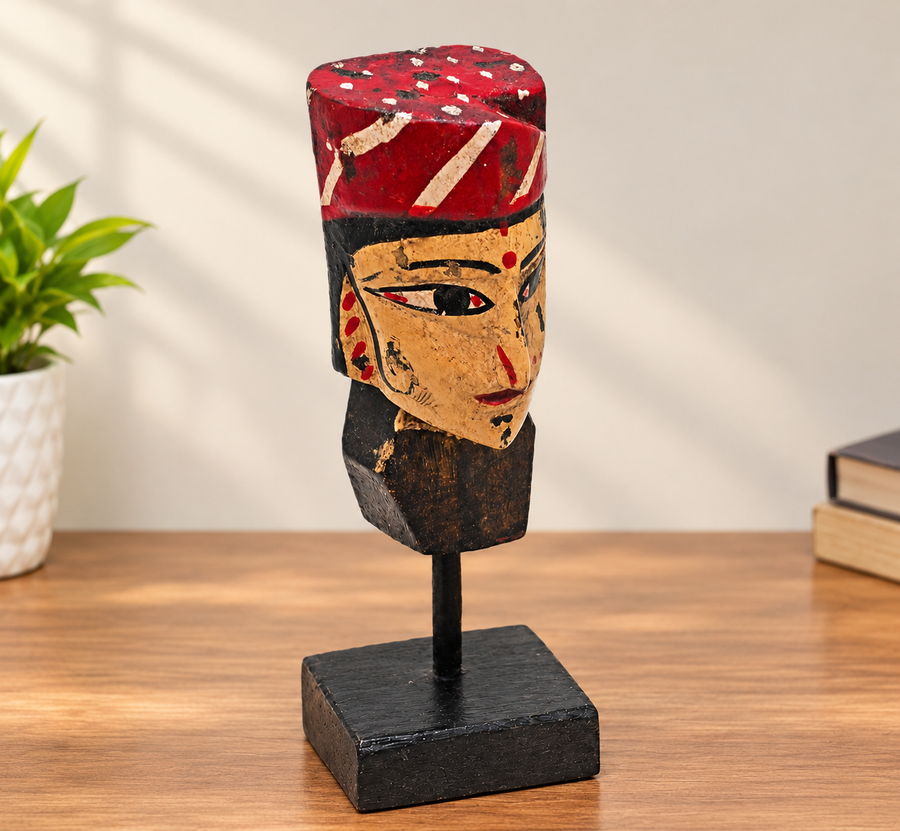 Handcrafted tribal queen bust with red and black painted face on wooden display stand, front view