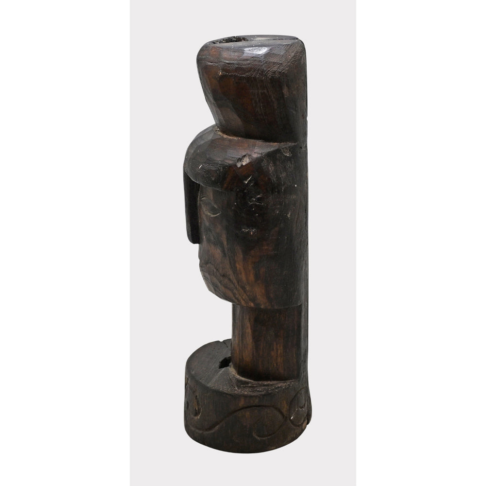 Dark aged wooden tribal face statue, close-up of decorative details