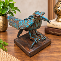 Blue antique iron bird figurine on wooden base, front view