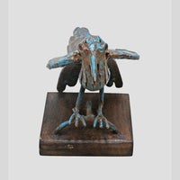 Close-up of metalwork on blue antique bird figurine