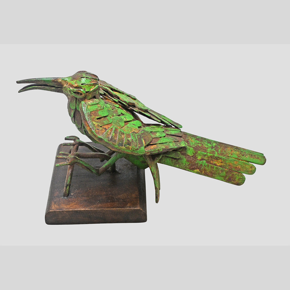 Close-up of metalwork on green antique bird figurine