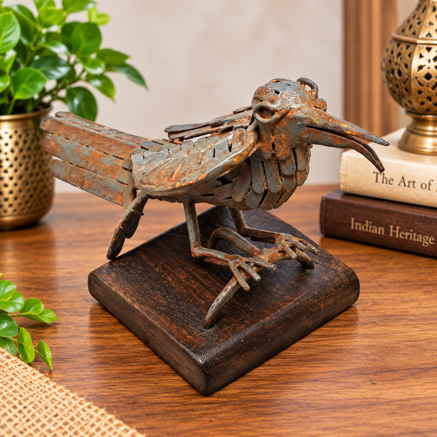 Grey antique iron bird figurine on wooden base, front view
