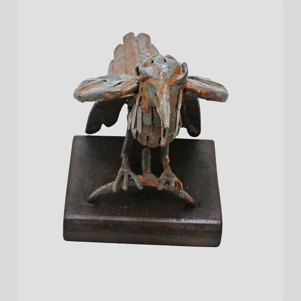 Grey iron bird figurine showing wooden base