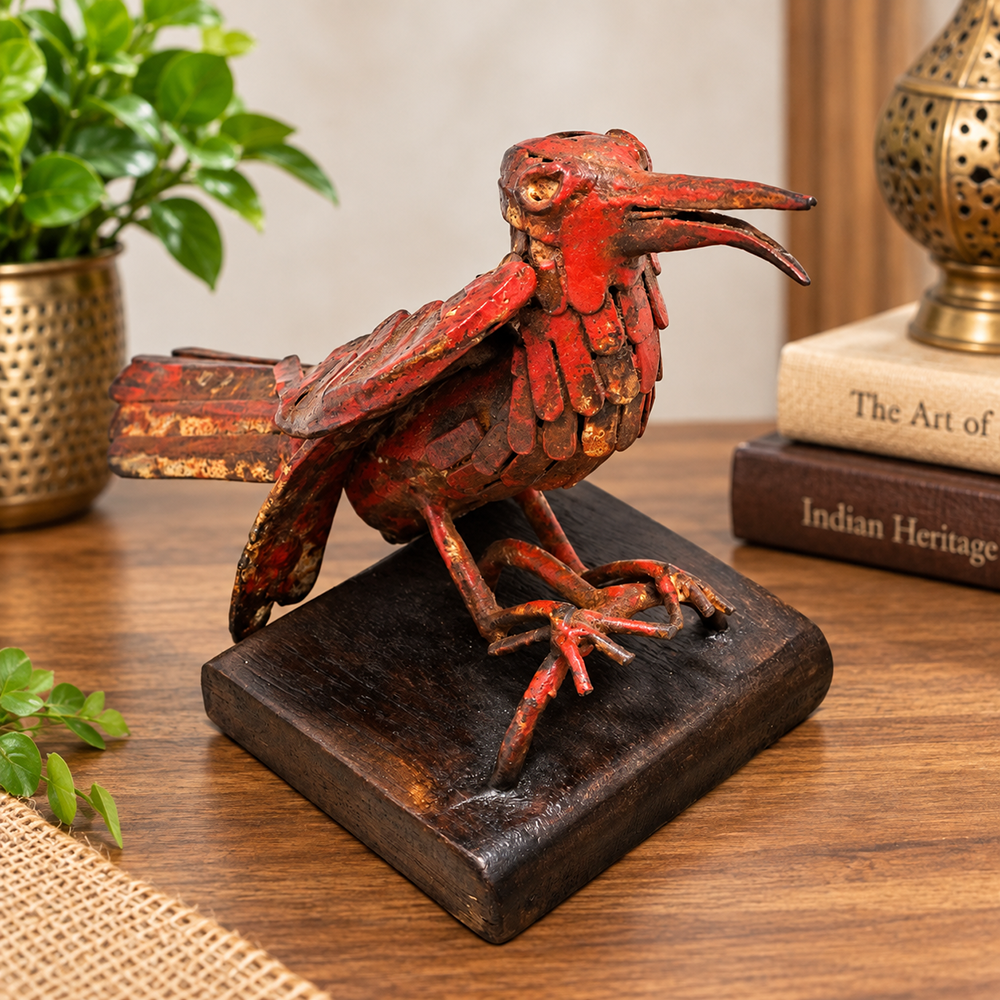 Red antique iron bird figurine on wooden base, front view