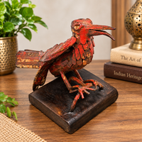 Red antique iron bird figurine on wooden base, front view