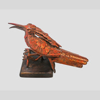 Red antique iron bird sculpture, angled view
