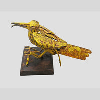 Yellow antique iron bird sculpture, angled view