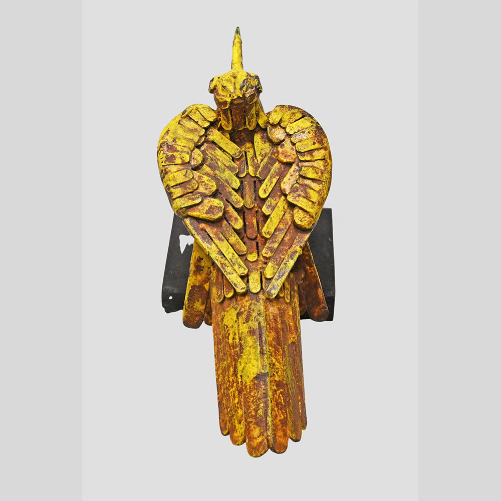 Close-up of metal detailing on yellow antique bird figurine