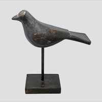 Black antique wooden bird figurine on stand, angled view