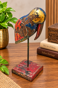 Hand-painted wooden bird figurine with multicolor details on red base, front view