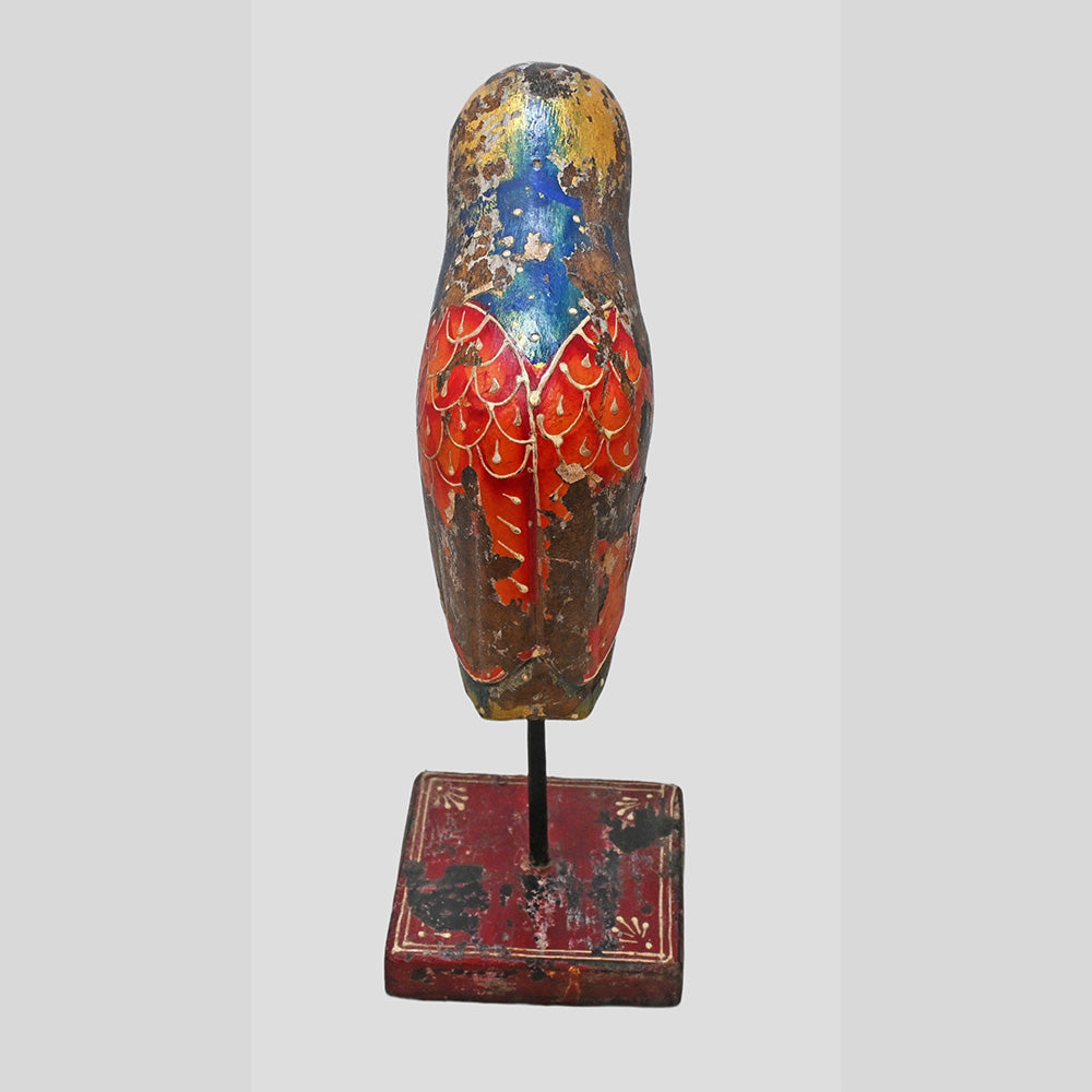 Side view of hand-painted wooden bird with extended tail