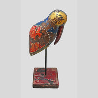 Angled view of colorful wooden bird sculpture on decorative stand