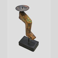 Close-up of iron candle plate and sculptural wooden stem