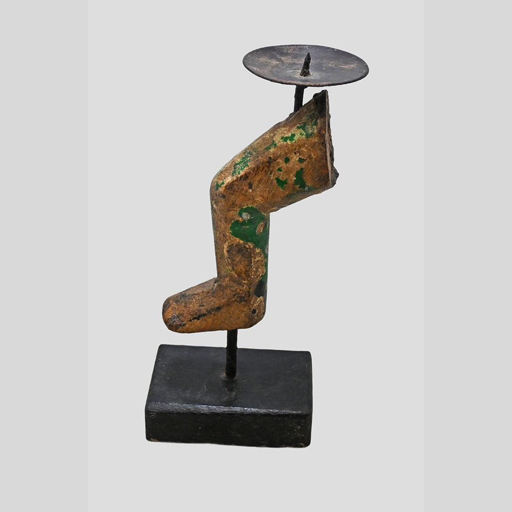 Angled view of antique finish wooden candle holder with iron candle plate