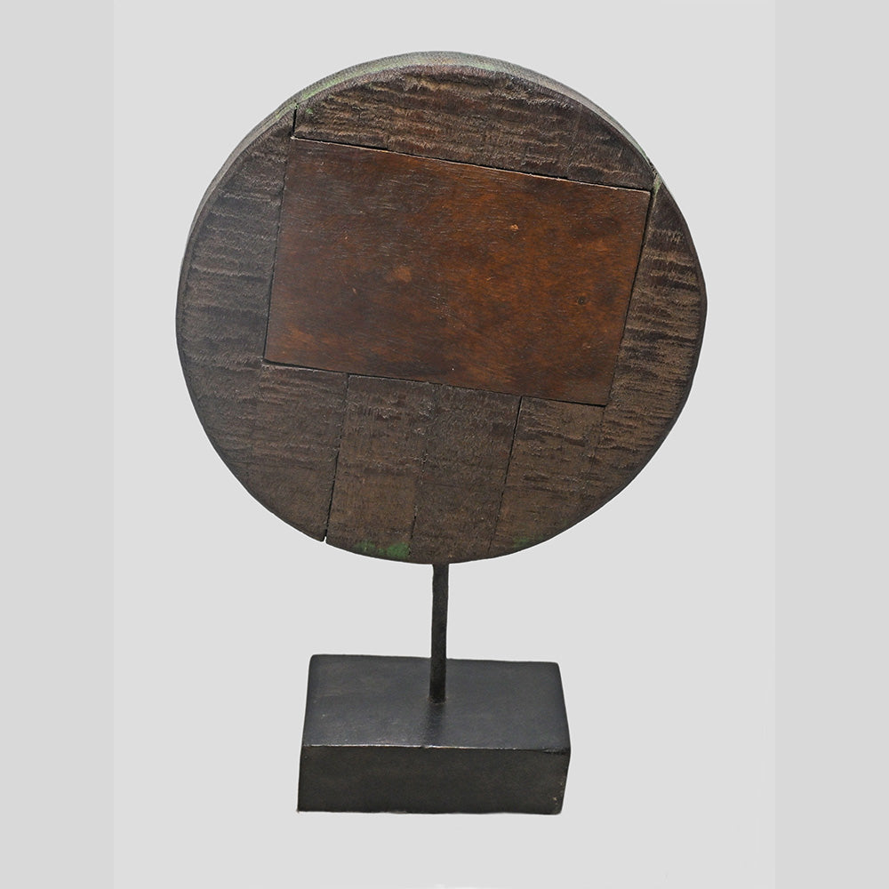 Side view of green wooden floral medallion mounted on support