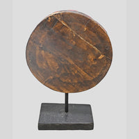 Side view of carved red wooden floral medallion on display stand