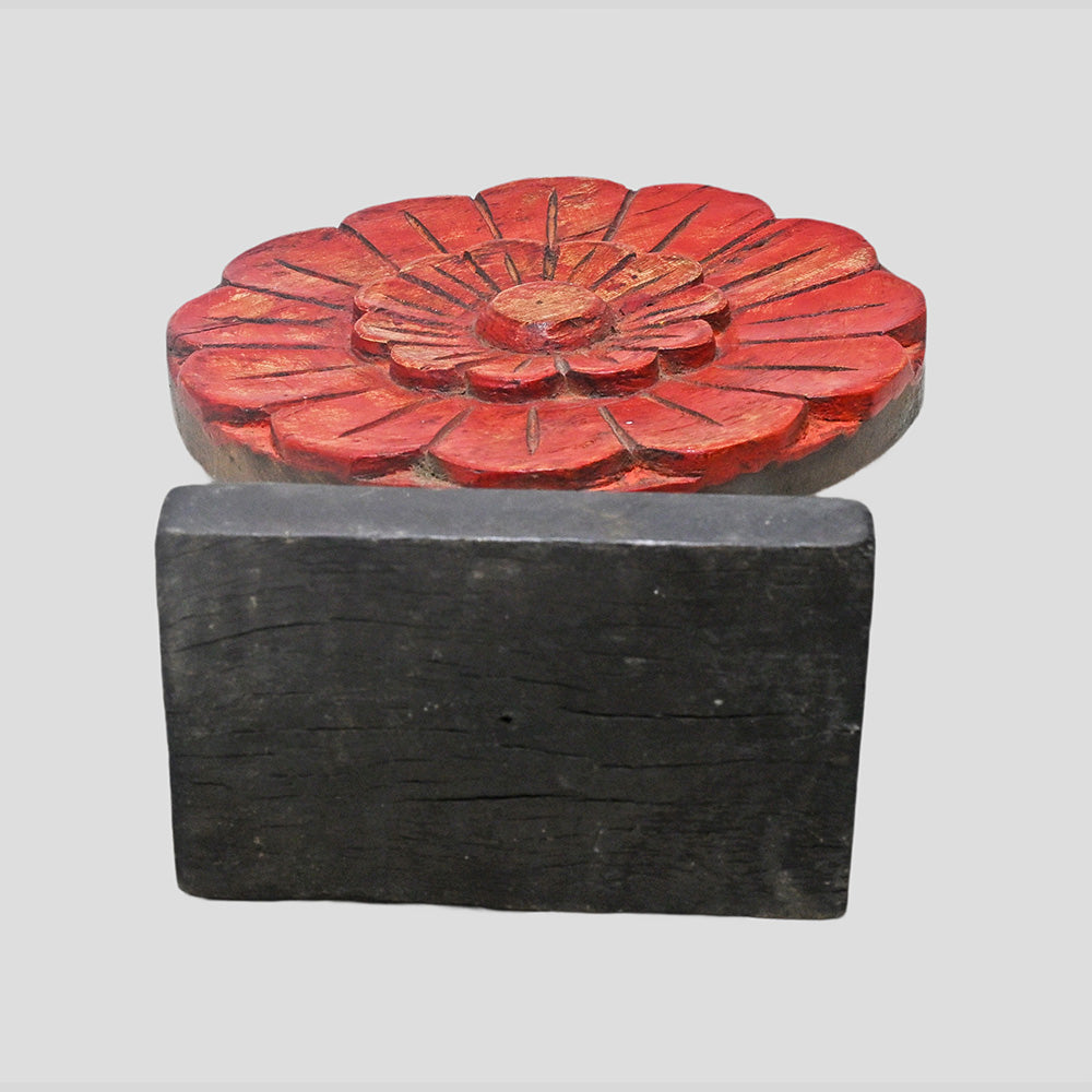 Detail of carved petals and aged finish on wooden floral medallion