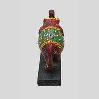 Side view of hand-painted wooden elephant with raised trunk