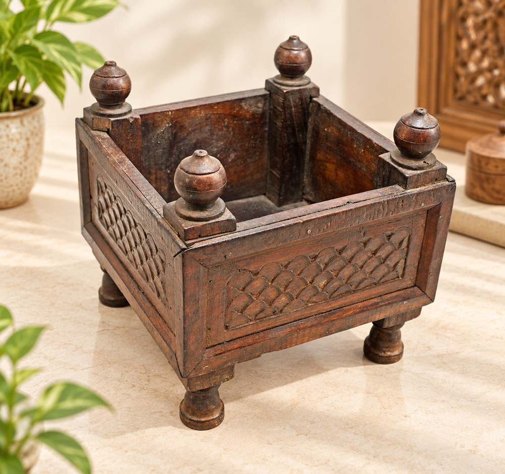 Vintage carved wooden storage box with raised legs and decorative corner posts, front view