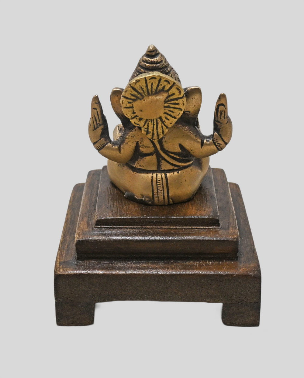 Brass Ganesha statue showing wooden Bajot display base
