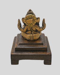 Brass Ganesha statue showing wooden Bajot display base