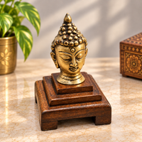 Brass meditating Buddha bust with detailed crown on wooden Bajot base, front view