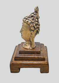 Close-up of antique brass Buddha face and crown details