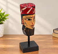Handcrafted tribal queen bust with red and black painted face on wooden display stand, front view