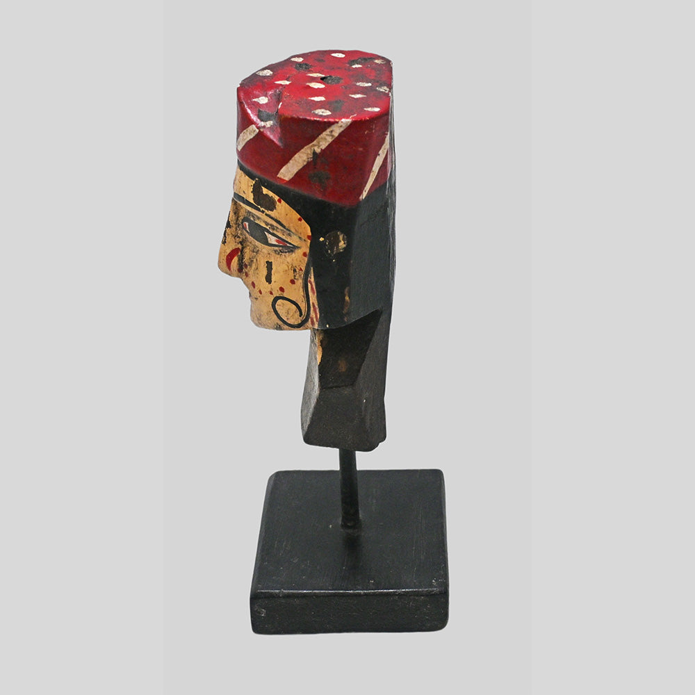 Side view of tribal queen bust sculpture on black wooden stand