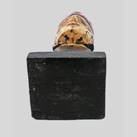 Rear view of tribal queen bust sculpture on display stand