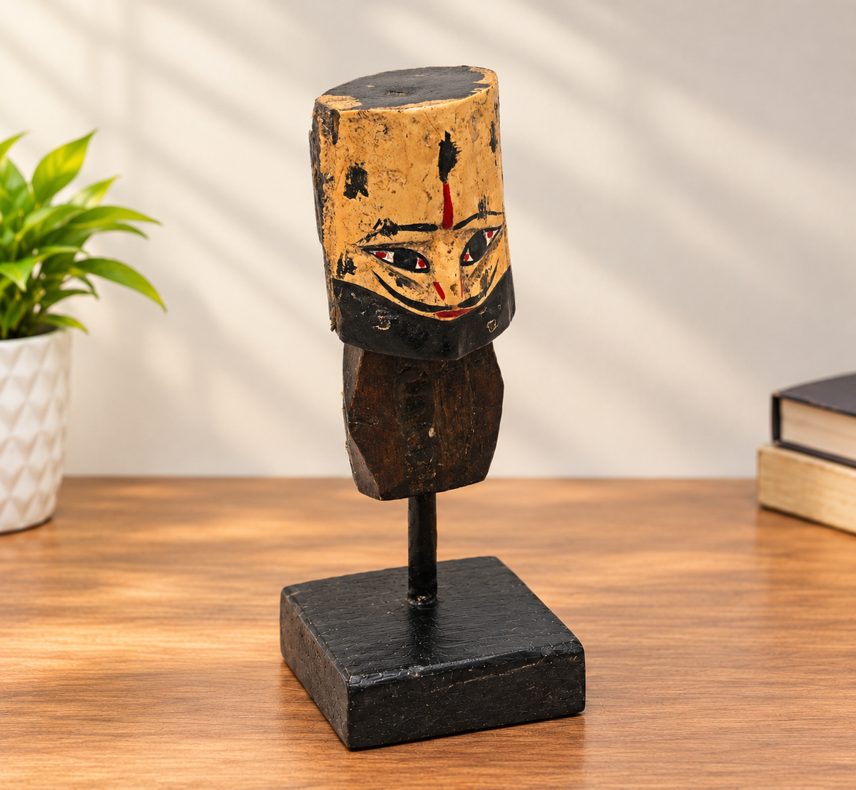 Handcrafted tribal king wooden bust sculpture on black display stand, front view