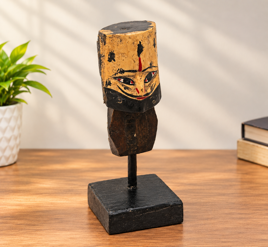 Handcrafted tribal king wooden bust sculpture on black display stand, front view