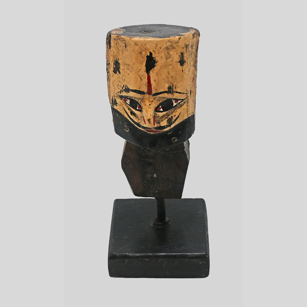 Close-up of carved face and folk art details on wooden tribal bust