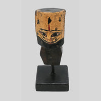 Close-up of carved face and folk art details on wooden tribal bust