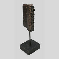 Angled view of dark brown carved wooden printing block