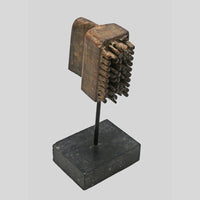 Angled view of vintage wooden textile printing block on stand