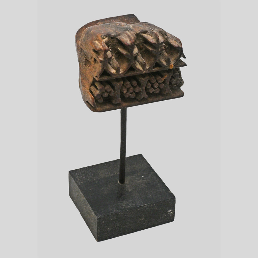 Angled view of antique floral and geometric wooden printing block
