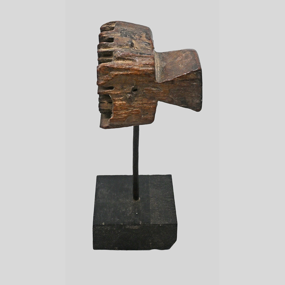 Side view of carved wooden textile printing block on stand