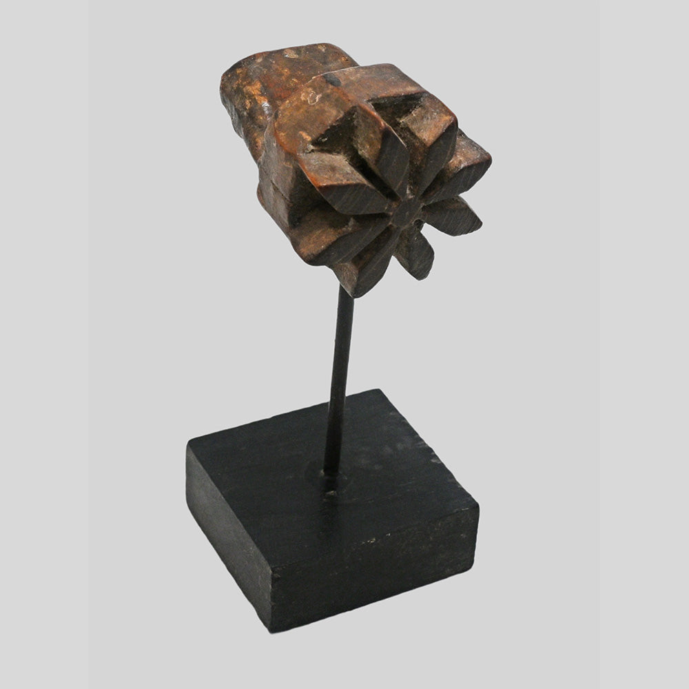 Angled view of star-shaped floral wooden printing block