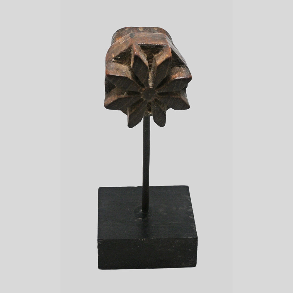 Close-up of raised floral star carving on teak wood block