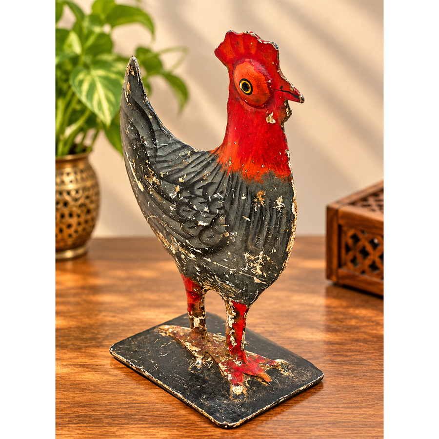 Vintage iron rooster figurine with red head and black distressed body, front view