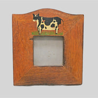 Traditional cow folk-art detail on wooden photo frame