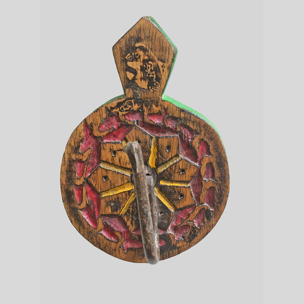 Floral carving detail on green wooden wall hanger