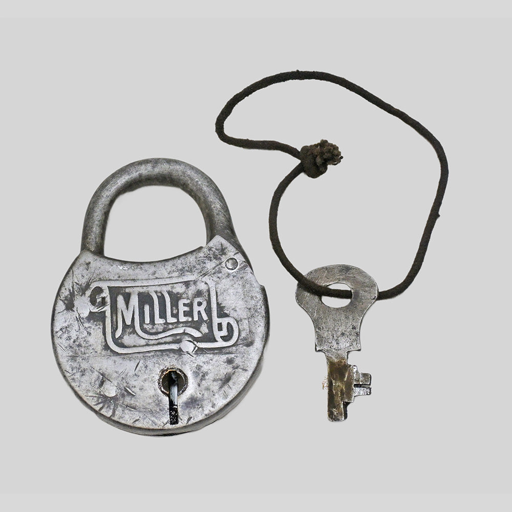 antique round iron padlock with silver finish and key, close-up detail