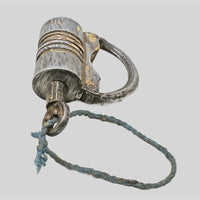 antique gold-tone ribbed metal padlock with original key, side view