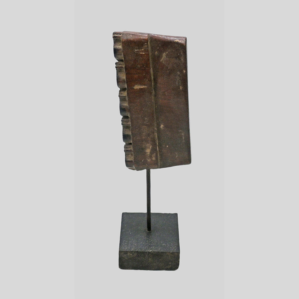 Side view of textile printing block on wooden stand