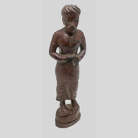 Side view of handcrafted teak wood musician figurine