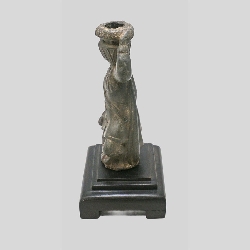 Antique cast metal man figurine carrying a pot, decorative candle holder, side view