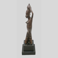 Vintage hand-carved wooden tribal figurine inspired by African art, close-up detail