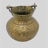 Antique brass holy water pot with engraved floral and traditional figures, close-up detail